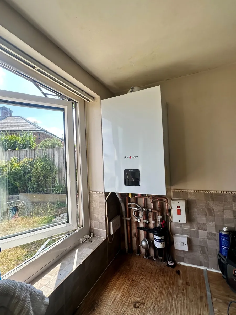 Glow-worm MicraCom combi boiler installed in a utility room with copper pipework and magnetic filter